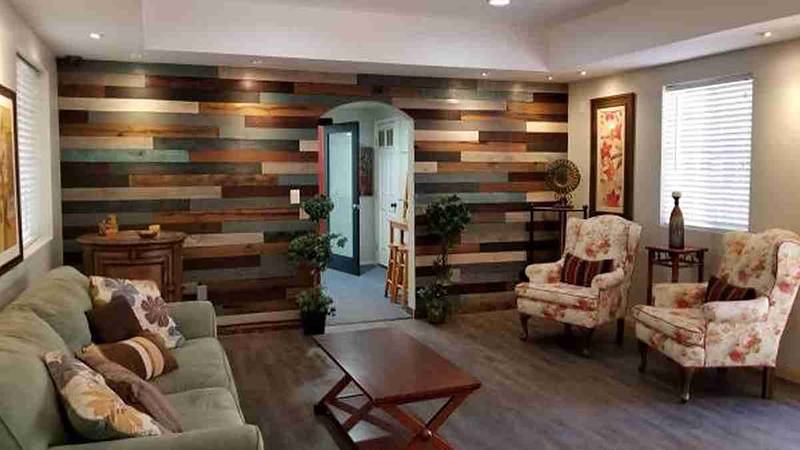 Living room with a multicolor wood wall and glass double doors to the patio