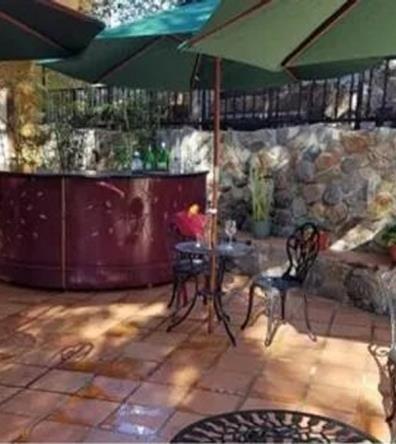 outdoor cafe with rock walls, serving bar on wheels and umbrellas filming location