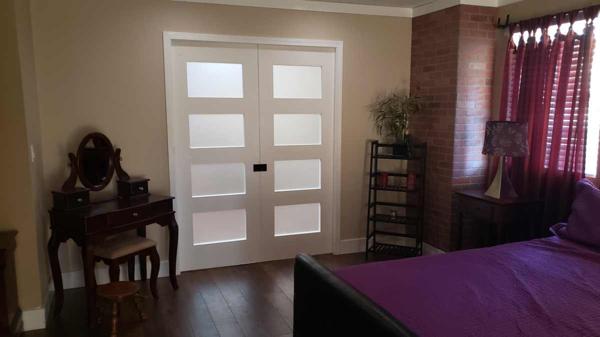 Opaque wood and glasss pocket doors open to kitchen area.